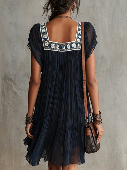 Tamara | Vestido corto de gasa plisada azul navy con bordados florales